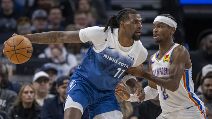 Jan 20, 2024; Minneapolis, Minnesota, USA; Minnesota Timberwolves center Naz Reid (11) backs towards the basket as Oklahoma City Thunder guard Shai Gilgeous-Alexander (2) plays defense in the first half at Target Center. Mandatory Credit: Jesse Johnson-Imagn Images