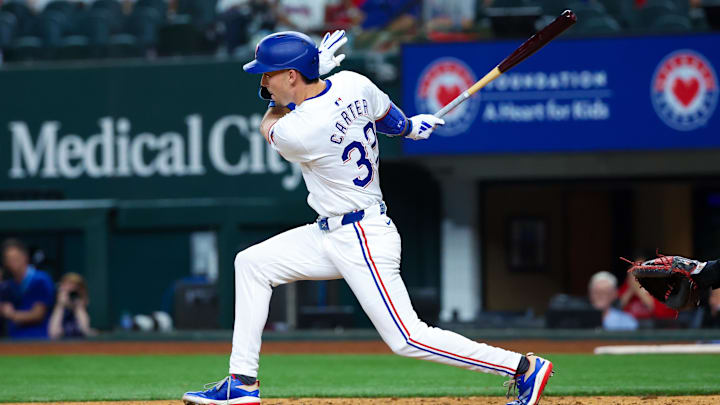 Apr 30, 2024; Arlington, Texas, USA;  Texas Rangers outfielder Evan Carter (32) hits an rbi single during the eighth inning against the Washington Nationals at Globe Life Field.