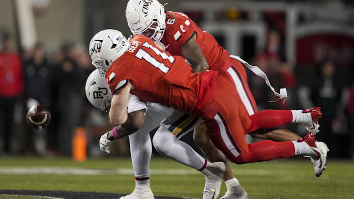Oct 25, 2025; Cincinnati, Ohio, USA; Baylor Bears tight end Michael Trigg (1) is unable to hold on to a catch as he is tackled by Cincinnati Bearcats linebacker Jake Golday (11) and defensive back Tre Gola-Callard (6) in the second half at Nippert Stadium. Mandatory Credit: Aaron Doster-Imagn Images Oct 25, 2025; Cincinnati, Ohio, USA; Baylor Bears tight end Michael Trigg (1) is unable to hold on to a catch as he is tackled by Cincinnati Bearcats linebacker Jake Golday (11) and defensive back Tre Gola-Callard (6) in the second half at Nippert Stadium. Mandatory Credit: Aaron Doster-Imagn Images