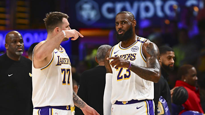 Mar 22, 2025; Los Angeles, California, USA; Los Angeles Lakers guard Luka Doncic (77) and Los Angeles Lakers forward LeBron James (23) on the sidelines against the Chicago Bulls during the first half at Crypto.com Arena. Mandatory Credit: Jonathan Hui-Imagn Images