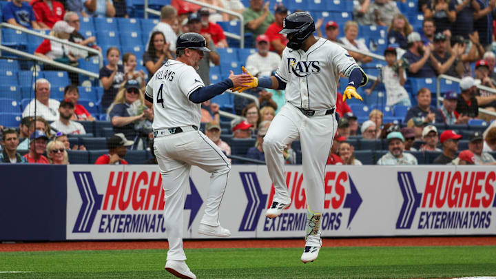 Apr 22, 2026; St. Petersburg, Florida, USA; Tampa Bay Rays third baseman Junior Caminero (13) celebrates with Tampa Bay Rays third base coach Brady Williams (4) after hitting a home run during the third inning against the Cincinnati Reds at Tropicana Field. Mandatory Credit: Mike Watters-Imagn Images