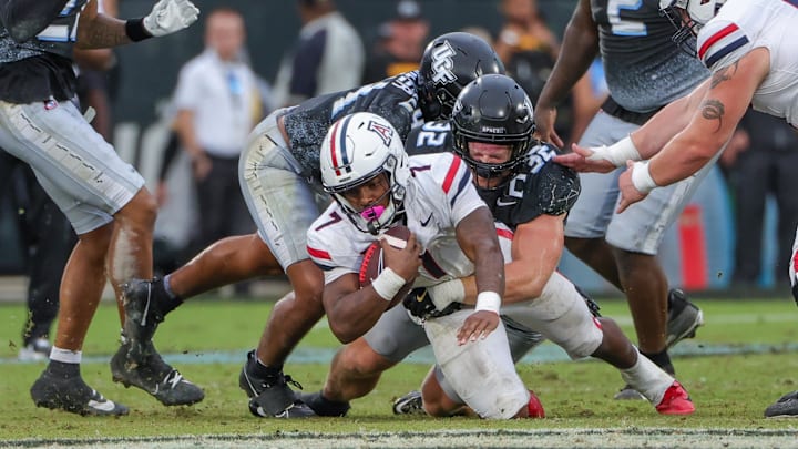 Nov 2, 2024; Orlando, Florida, USA; Arizona Wildcats running back Quali Conley (7) is tackled by UCF Knights linebacker Ethan Barr (32) during the second half at FBC Mortgage Stadium.