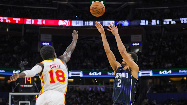 Orlando Magic guard Caleb Houstan (2) shoots a three-point basket against Atlanta Hawks forward Mouhamed Gueye (18) during the second half at Kia Center.