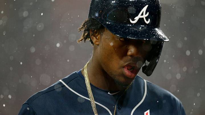 Atlanta Braves left fielder Ronald Acuna Jr. (13) walks for the dugout as the grounds crew covers the field after the top of the seventh inning of the MLB National League game between the Cincinnati Reds and the Atlanta Braves at Great American Ball Park in downtown Cincinnati on Thursday, April 25, 2019. The Reds carried a 3-0 lead as the game entered a rain delay in the seventh inning. 

Atlanta Braves At Cincinnati Reds