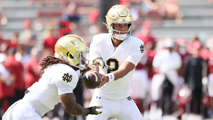 Sep 27, 2025; Fayetteville, Arkansas, USA; Notre Dame Fighting Irish quarterback Kenny Minchey (8) hands the ball off during the fourth quarter against the Arkansas Razorbacks at Donald W. Reynolds Razorback Stadium. Notre Dame won 56-13. Mandatory Credit: Nelson Chenault-Imagn Images