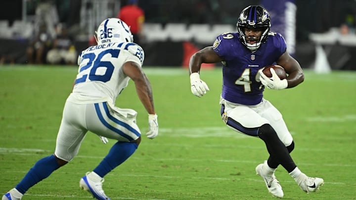 Aug 7, 2025; Baltimore, Maryland, USA; Baltimore Ravens linebacker Jay Higgins IV (49) runs back an interception in front of Indianapolis Colts running back Khalil Herbert (26) during the fourth quarter at M&T Bank Stadium. Mandatory Credit: Rafael Suanes-Imagn Images