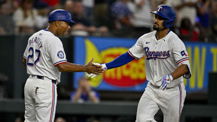Jul 6, 2024; Arlington, Texas, USA; Texas Rangers second baseman Marcus Semien (2) and third base coach Tony Beasley (27) celebrate after Semien hits a two-run home run to give the Rangers the lead over the Tampa Bay Rays during the seventh inning at Globe Life Field. Mandatory Credit: Jerome Miron-USA TODAY Sports