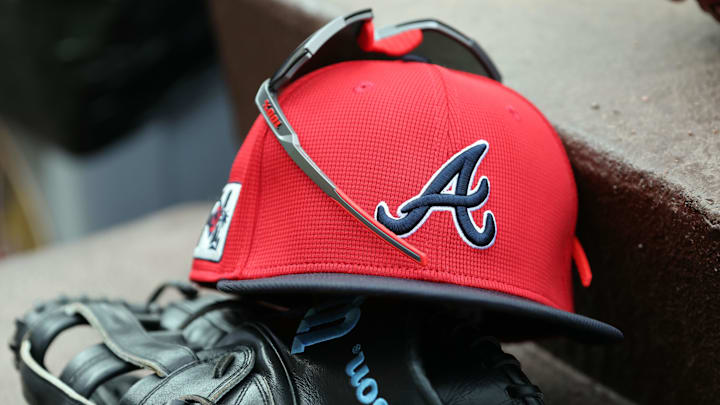 wMar 1, 2025; North Port, Florida, USA; A detail view of Atlanta Braves hat, sunglasses and glove in the dugout during the fifth inning at CoolToday Park. Mandatory Credit: Kim Klement Neitzel-Imagn Images