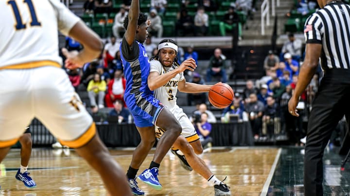 Wayne Memorial's Carlos Medlock Jr., right, moves past Flint Carman-Ainsworth's Fred Thomas IV during the fourth quarter in the Division 1 state semifinal on Friday, March 14, 2025, at the Breslin Center in East Lansing.