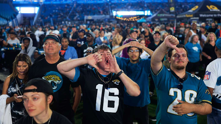 Coleman Marley, center, boos expressing his opinion of NFL Commissioner Roger Goodell kicks off the NFL Draft as Adam Watson gives a thumbs down, right, and Chandler Foster, back, looks on during the Duuuval Draft Party Thursday, April 25, 2024 at EverBank Stadium in Jacksonville, Fla. 