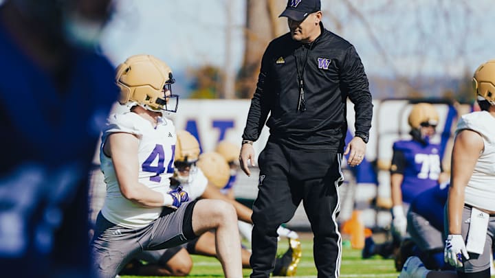 Hayden Moore and linebackers coach Brian Odom commiserate during stretching drills.