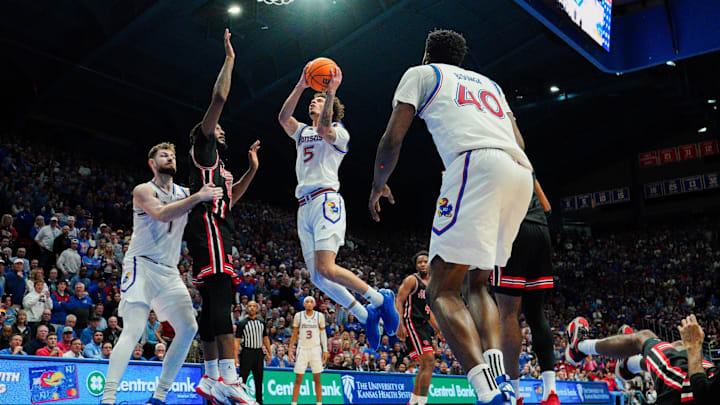Jan 25, 2025; Lawrence, Kansas, USA; Kansas Jayhawks guard Zeke Mayo (5) shoots as Houston Cougars forward Ja'Vier Francis (5) defends during the second half at Allen Fieldhouse. Mandatory Credit: Denny Medley-Imagn Images