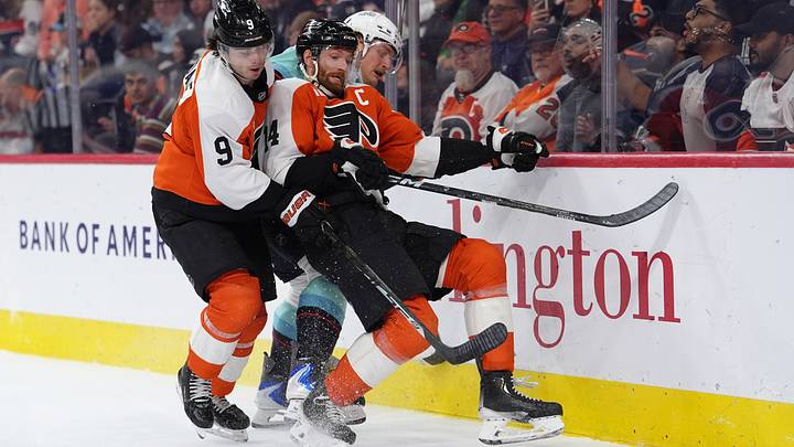 Oct 13, 2026; Philadelphia, Pennsylvania, USA; Philadelphia Flyers center Sean Couturier (14) and defenseman Jamie Drysdale (9) collide with Seattle Kraken center Bobby McMann (74) in the second period at Xfinity Mobile Arena.