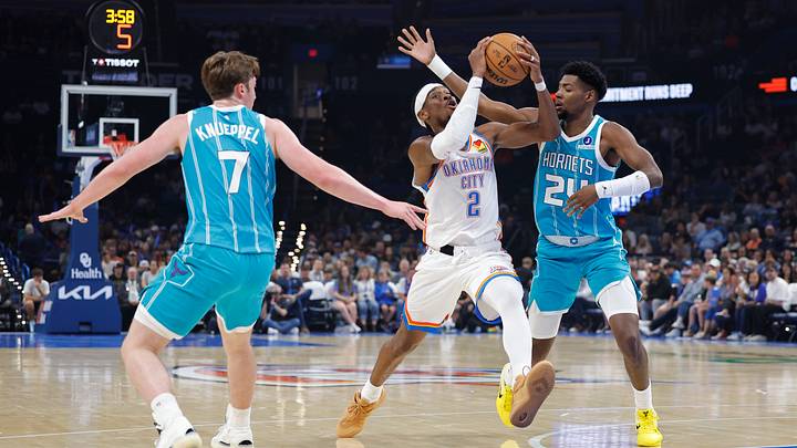 Shai Gilgeous-Alexander (2) drives down the court between Charlotte Hornets guard/forward Kon Knueppel (7) and forward Brandon Miller Shai Gilgeous-Alexander (2) drives down the court between Charlotte Hornets guard/forward Kon Knueppel (7) and forward Brandon Miller