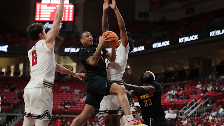 Dec 28, 2025; Lubbock, Texas, USA;  Winthrop Eagles guard Isaiah Wilson (1) drives to the basket between Texas Tech Red Raiders guard Nolan Groves (8) and forward Leon Horner (6) in the second half at United Supermarkets Arena. Mandatory Credit: Michael C. Johnson-Imagn Images