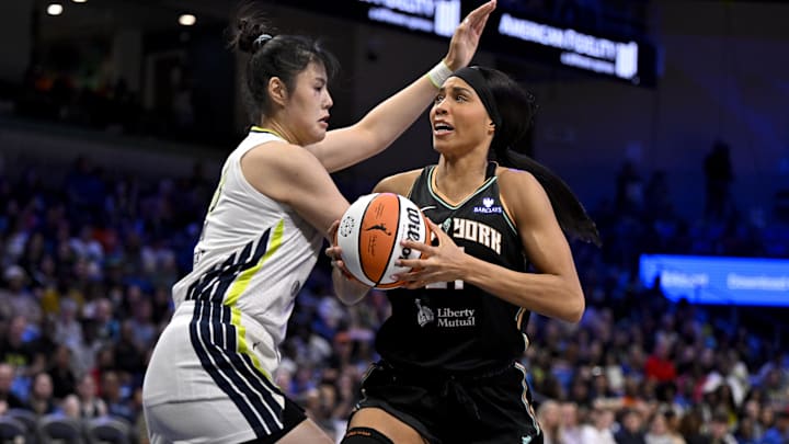 Jul 28, 2025; Arlington, Texas, USA; New York Liberty forward Isabelle Harrison (21) moves the ball past Dallas Wings center Li Yueru (28) during the second half at College Park Center. Mandatory Credit: Jerome Miron-Imagn Images
