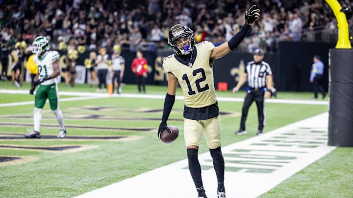 Dec 21, 2025; New Orleans, Louisiana, USA; New Orleans Saints wide receiver Chris Olave (12) waves to fans after scoring a touchdown against New York Jets cornerback Brandon Stephens (21) during the second half at Caesars Superdome. Mandatory Credit: Stephen Lew-Imagn Images Dec 21, 2025; New Orleans, Louisiana, USA; New Orleans Saints wide receiver Chris Olave (12) waves to fans after scoring a touchdown against New York Jets cornerback Brandon Stephens (21) during the second half at Caesars Superdome. Mandatory Credit: Stephen Lew-Imagn Images