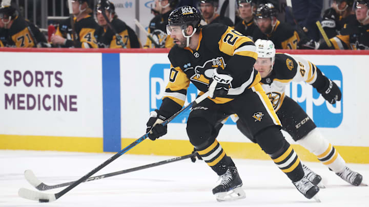 Apr 13, 2025; Pittsburgh, Pennsylvania, USA; Pittsburgh Penguins defenseman Conor Timmins (20) skates with the puck against Boston Bruins left wing Cole Koepke (45) during the second period at PPG Paints Arena. Mandatory Credit: Charles LeClaire-Imagn Images