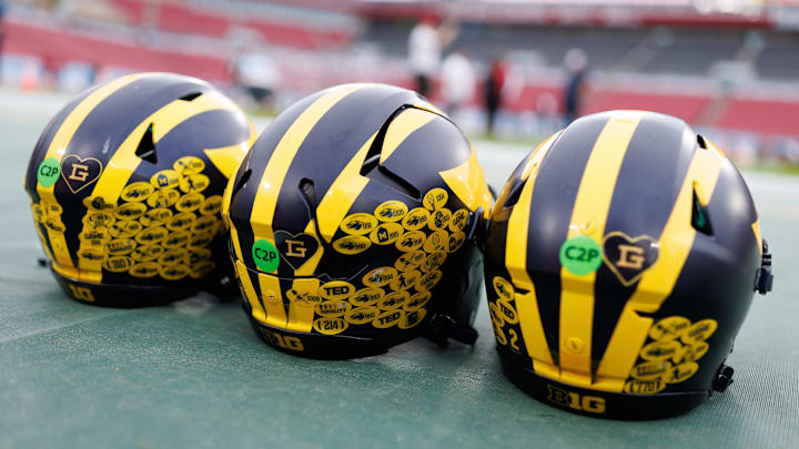 Dec 31, 2024; Tampa, FL, USA; Michigan Wolverines quarterback helmets sit on the field before a game against the Alabama Crimson Tide at Raymond James Stadium. Mandatory Credit: Matt Pendleton-Imagn Images