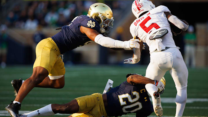 Notre Dame corner back Benjamin Morrison (20) and linebacker Jaiden Ausberry (4) tackle Stanford running back Chris Davis Jr. (5) during a NCAA college football game between Notre Dame and Stanford at Notre Dame Stadium on Saturday, Oct. 12, 2024, in South Bend.