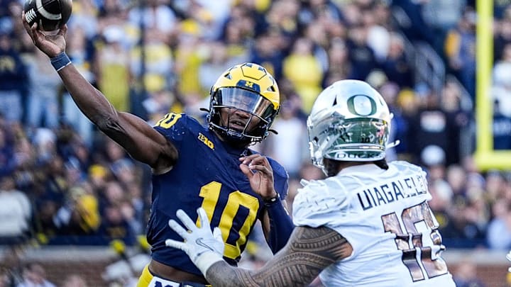 Michigan quarterback Alex Orji (10) makes a pass against Oregon defensive end Matayo Uiagalelei (10) during the first half at Michigan Stadium in Ann Arbor on Saturday, Nov. 2, 2024. Michigan quarterback Alex Orji (10) makes a pass against Oregon defensive end Matayo Uiagalelei (10) during the first half at Michigan Stadium in Ann Arbor on Saturday, Nov. 2, 2024.