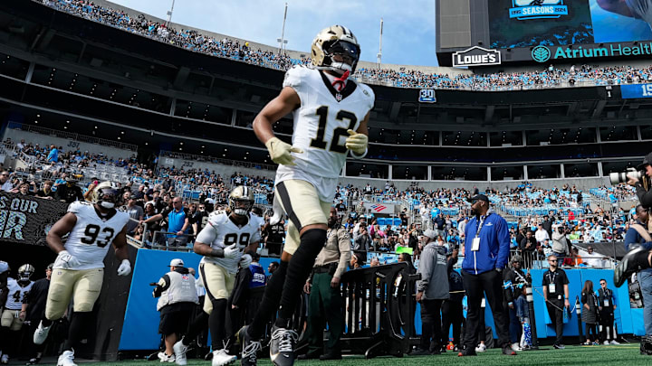 Nov 3, 2024; Charlotte, North Carolina, USA; New Orleans Saints wide receiver Chris Olave (12) runs on to the field before the game at Bank of America Stadium. Mandatory Credit: Bob Donnan-Imagn Images