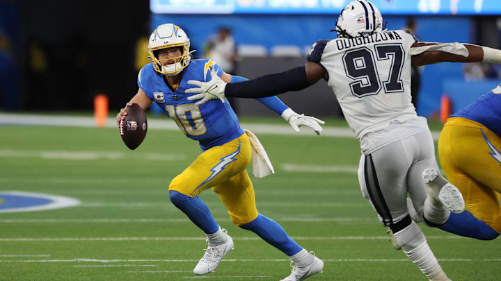 Los Angeles Chargers quarterback Justin Herbert runs away from Dallas Cowboys defensive tackle Osa Odighizuwa. Los Angeles Chargers quarterback Justin Herbert runs away from Dallas Cowboys defensive tackle Osa Odighizuwa.