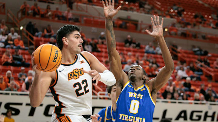 Feb 24, 2026; Stillwater, Oklahoma, USA; Oklahoma State Cowboys forward Parsa Fallah (22) passes the ball around West Virginia Mountaineers forward Brenen Lorient (0) during the first half at Gallagher-Iba Arena. Mandatory Credit: William Purnell-Imagn Images