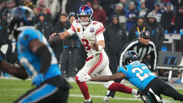 Nov 10, 2024; Munich, Germany; New York Giants quarterback Daniel Jones (8) is pressured by Carolina Panthers cornerback Dane Jackson (23) in the second half during the 2024 NFL Munich Game at Allianz Arena. Mandatory Credit: Kirby Lee-Imagn Images