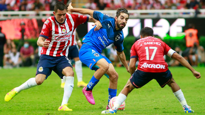 Rodolfo Pizarro intenta defender el esférico de Sergio Flores y Jesús Sánchez.