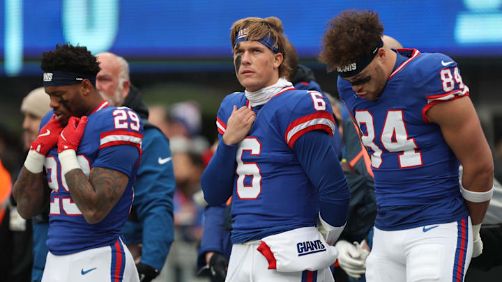 Dec 14, 2025; East Rutherford, New Jersey USA;  (l-r) New York Giants running back Tyrone Tracy Jr. (29) and quarterback Jaxson Dart (6) and tight end Theo Johnson (84) during the National anthem prior to the first quarter against the Washington Commanders at MetLife Stadium.  