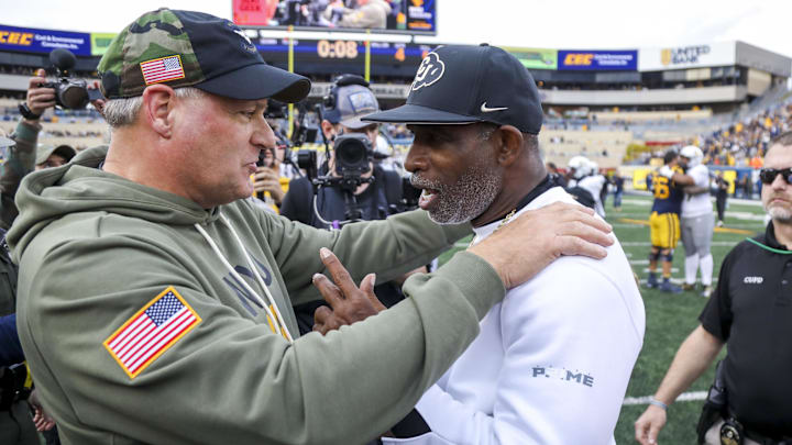 Nov 8, 2025; Morgantown, West Virginia, USA; West Virginia Mountaineers head coach Rich Rodriguez talks with Colorado Buffaloes head coach Deion Sanders after the game at Milan Puskar Stadium. Mandatory Credit: Ben Queen-Imagn Images