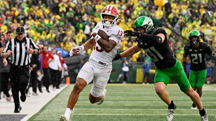 Oct 11, 2025; Eugene, Oregon, USA; Indiana Hoosiers wide receiver Elijah Sarratt (13) runs with the ball after making a catch against Oregon Ducks defensive back Dillon Thieneman (31) during the fourth quarter at Autzen Stadium. Mandatory Credit: Troy Wayrynen-Imagn Images