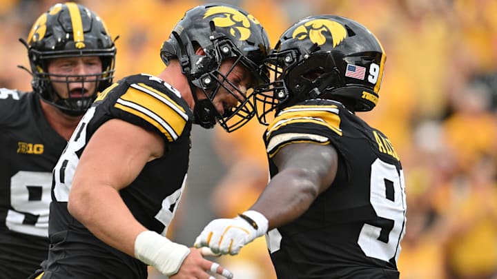 Sep 14, 2024; Iowa City, Iowa, USA; Iowa Hawkeyes defensive lineman Max Llewellyn (48) reacts with defensive end Brian Allen (90) as defensive lineman Aaron Graves (rear) looks on during the third quarter against the Troy Trojans at Kinnick Stadium. Mandatory Credit: Jeffrey Becker-Imagn Images