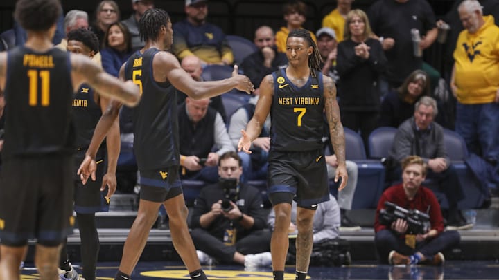 Feb 8, 2025; Morgantown, West Virginia, USA; West Virginia Mountaineers guard Javon Small (7) celebrates with West Virginia Mountaineers guard Toby Okani (5) following a score during the second half against the Utah Utes at WVU Coliseum. Mandatory Credit: Ben Queen-Imagn Images