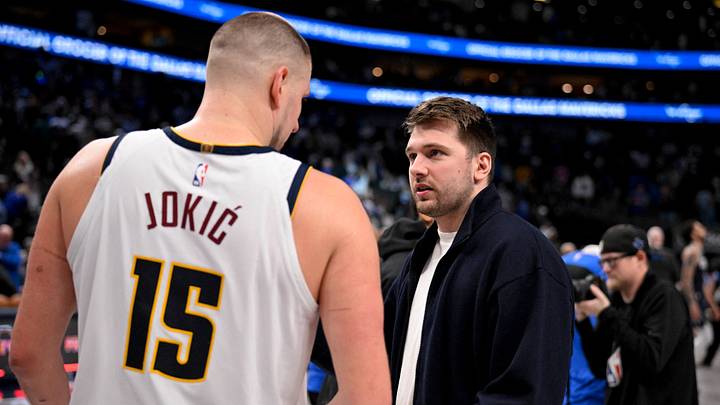 Luka Doncic talks with Denver Nuggets center Nikola Jokic.
