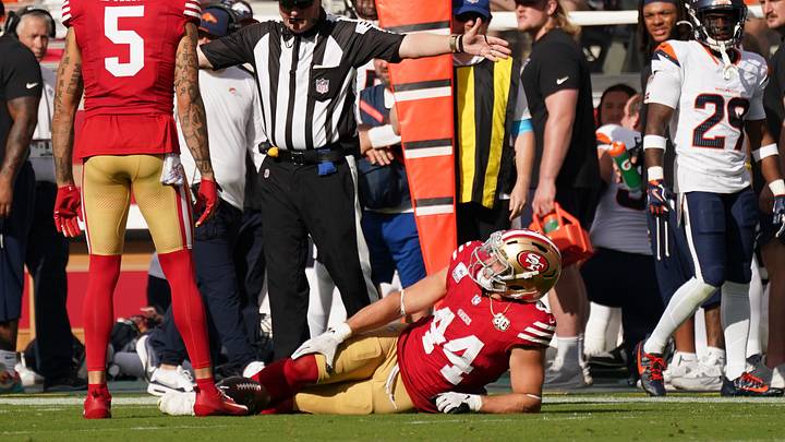 Santa Clara, California, USA;  San Francisco 49ers fullback Kyle Juszczyk (44) grabs his knee after being tackled by Denver Broncos cornerback Jahdae Barron during the second half at Levi's Stadium.  Mandatory Credit: David Gonzales-Imagn Images