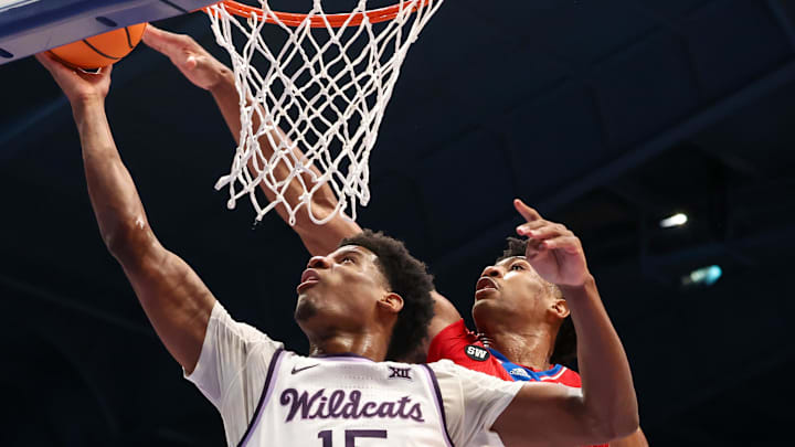 Mar 7, 2026; Lawrence, Kansas, USA; Kansas State Wildcats forward Taj Manning (15) goes to the basket against Kansas Jayhawks forward Bryson Tiller (15) during the first half at Allen Fieldhouse. Mandatory Credit: Scott Sewell-Imagn Images