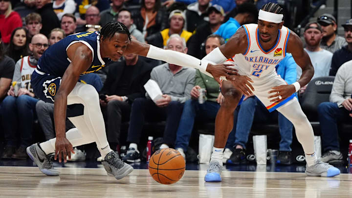 Nov 6, 2024; Denver, Colorado, USA; Denver Nuggets forward Peyton Watson (8) and Oklahoma City Thunder guard Shai Gilgeous-Alexander (2) reach for a loose ball in the first quarter at Ball Arena. Mandatory Credit: Ron Chenoy-Imagn Images