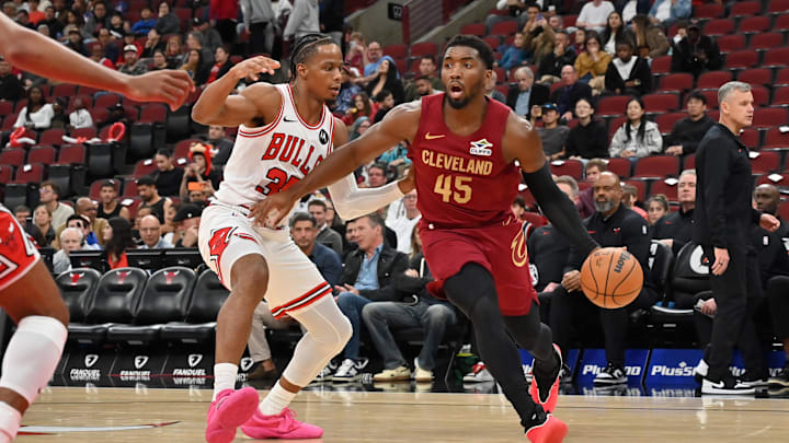 Oct 9, 2025; Chicago, Illinois, USA; Cleveland Cavaliers guard Donovan Mitchell (45) drives against Chicago Bulls forward/guard Isaac Okoro (35) during the first half at United Center. Mandatory Credit: Patrick Gorski-Imagn Images