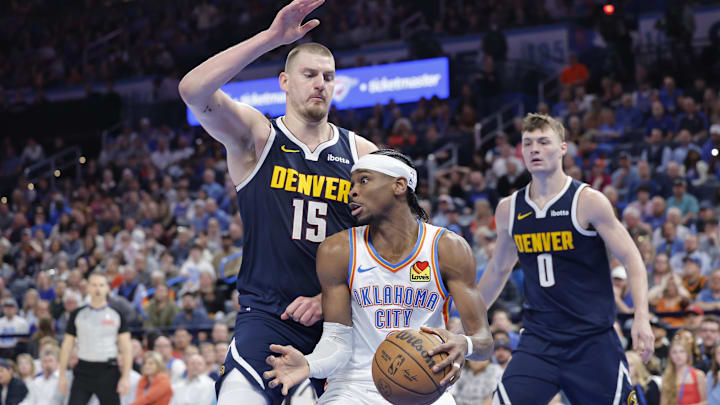 Mar 10, 2025; Oklahoma City, Oklahoma, USA; Denver Nuggets center Nikola Jokic (15) defends a drive by Oklahoma City Thunder guard Shai Gilgeous-Alexander (2) during the second half at Paycom Center. Mandatory Credit: Alonzo Adams-Imagn Images