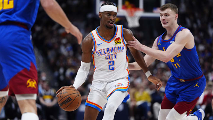 May 9, 2025; Denver, Colorado, USA; Denver Nuggets guard Christian Braun (0) defends Oklahoma City Thunder guard Shai Gilgeous-Alexander (2) in the first quarter during game three of the second round for the 2025 NBA Playoffs at Ball Arena. Mandatory Credit: Ron Chenoy-Imagn Images