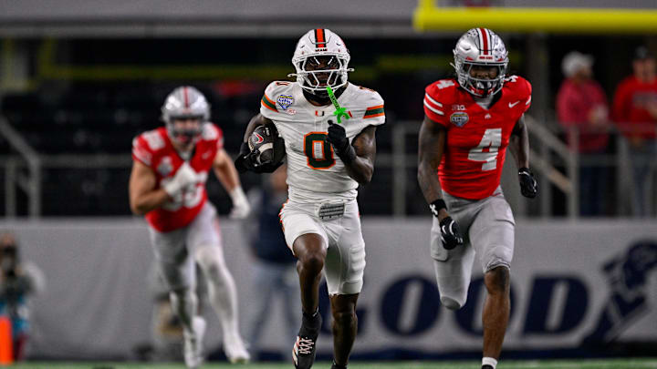 Dec 31, 2025; Arlington, TX, USA; Miami Hurricanes defensive back Keionte Scott (0) returns an interception for a touchdown as Ohio State Buckeyes wide receiver Jeremiah Smith (4) chases during the 2025 Cotton Bowl and quarterfinal game of the College Football Playoff at AT&T Stadium. Mandatory Credit: Jerome Miron-Imagn Images