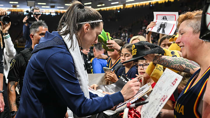 Indiana Fever guard Caitlin Clark (22) signs autographs for fans after the game against the Brazil National Team at Carver-Haweye Arena.