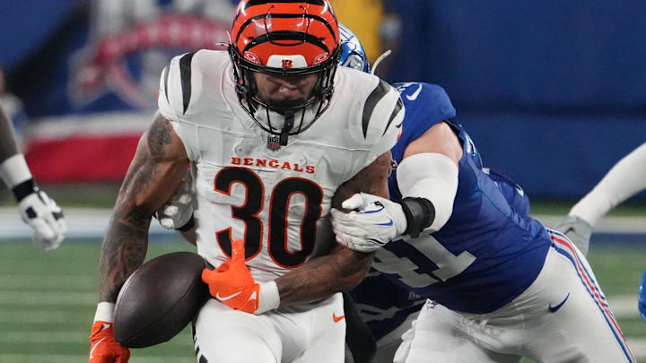Oct 13, 2024; East Rutherford, New Jersey, USA;  Cincinnati Bengals running back Chase Brown (30) fumbles the ball late in the fourth quarter as New York Giants linebacker Micah McFadden (41) defends at MetLife Stadium. The ball went out of bounds. Mandatory Credit: Robert Deutsch-Imagn Images 