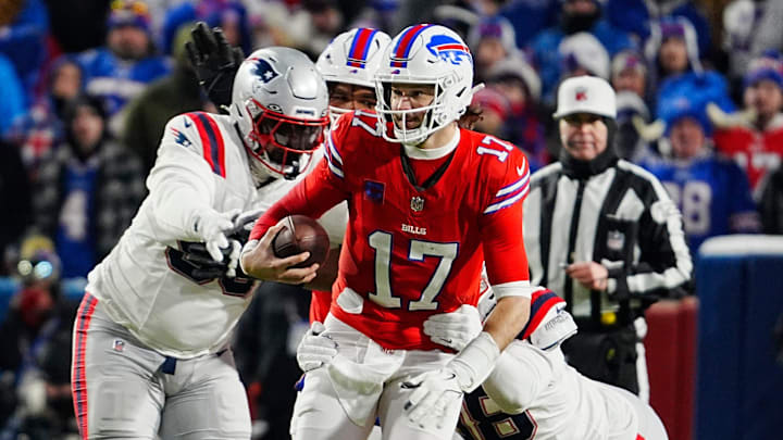 Buffalo Bills quarterback Josh Allen avoids New England Patriots Daniel Ekuale and breaks Jeremiah Pharms Jr. 's attempted tackle to gain several yards on a carry during first half action at Highmark Stadium where the Buffalo Bills hosted the New England Patriots in Orchard Park on Dec. 22, 2024.
