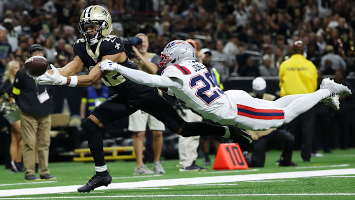 New Orleans Saints WR Chris Olave (12) tries to catch a ball while being defended by New England Patriots CB Marcus Jones (25)