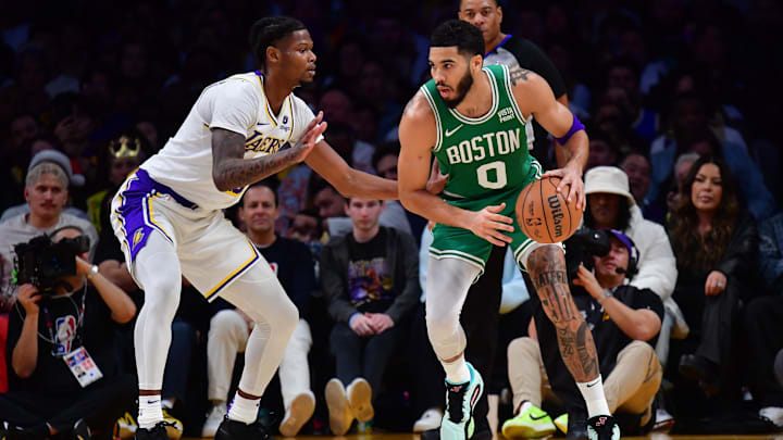 Dec 25, 2023; Los Angeles, California, USA; Boston Celtics forward Jayson Tatum (0) moves the ball against Los Angeles Lakers forward Cam Reddish (5) during the first half at Crypto.com Arena. Mandatory Credit: Gary A. Vasquez-Imagn Images