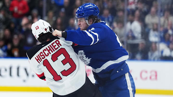 Dec 30, 2025; Toronto, Ontario, CAN; Toronto Maple Leafs left wing Matthew Knies (23) fights with New Jersey Devils center Nico Hischier (13) during the third period at Scotiabank Arena. Mandatory Credit: Nick Turchiaro-Imagn Images