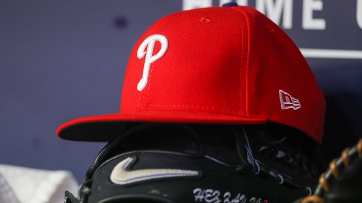 May 26, 2023; Atlanta, Georgia, USA; A detailed view of a Philadelphia Phillies hat and glove on the bench against the Atlanta Braves in the seventh inning at Truist Park. Mandatory Credit: Brett Davis-Imagn Images